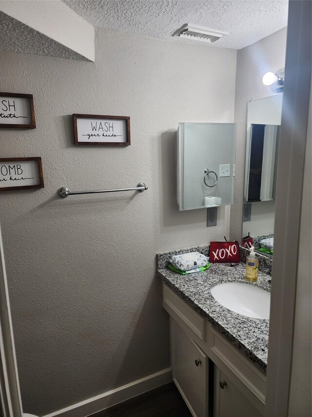 bathroom with vanity and a textured ceiling