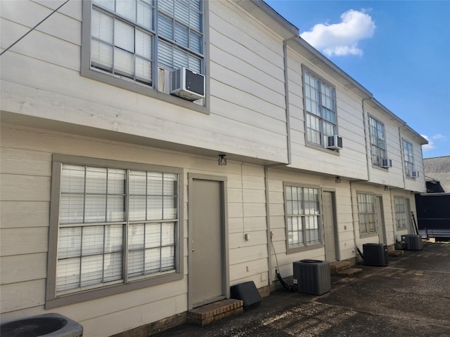 rear view of property with central AC and cooling unit