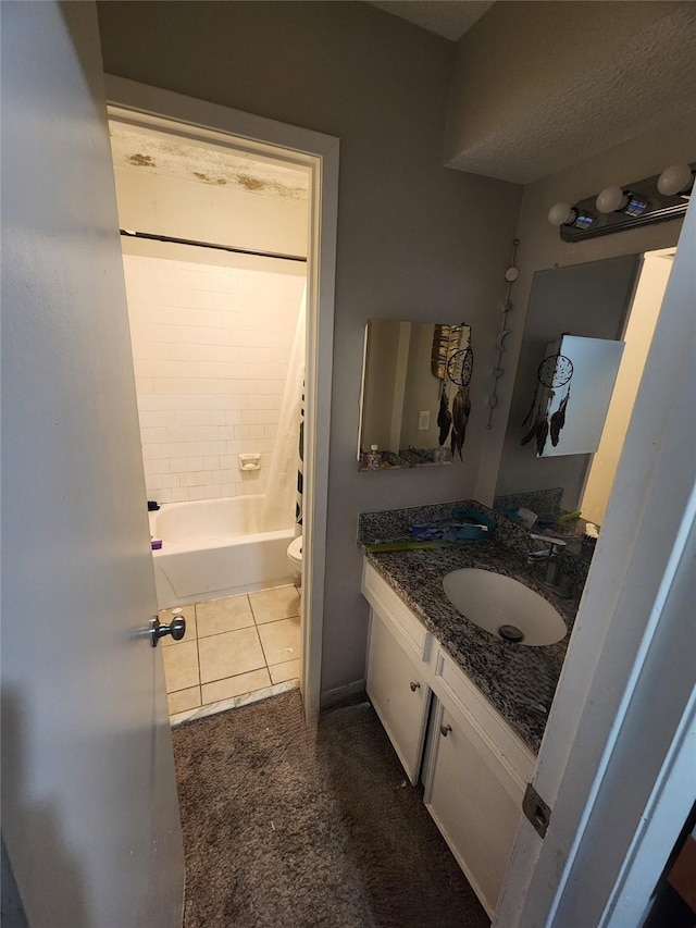 full bathroom featuring tile patterned floors, vanity, tiled shower / bath combo, and toilet