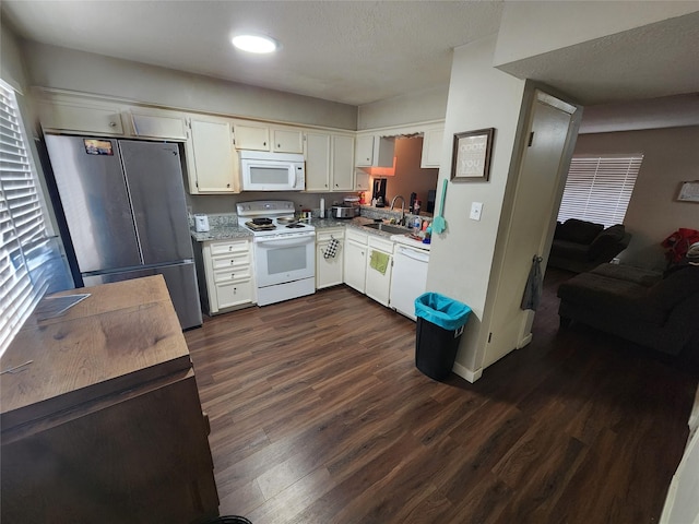 kitchen with white cabinetry, sink, dark hardwood / wood-style floors, and white appliances