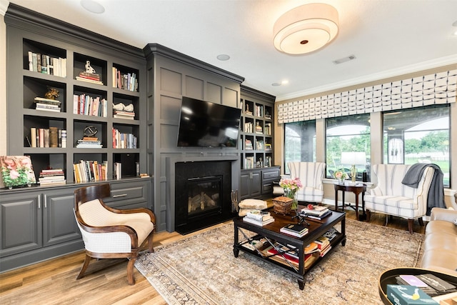 living room featuring light hardwood / wood-style flooring and ornamental molding