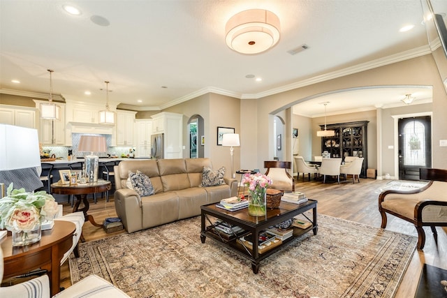 living room with crown molding and light wood-type flooring