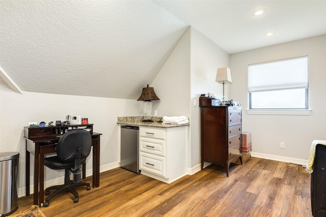 office space featuring vaulted ceiling, dark wood-type flooring, and a textured ceiling