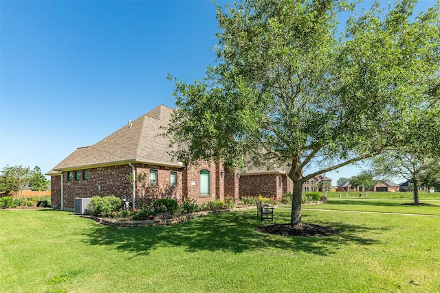 exterior space featuring central AC and a front yard