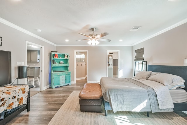 bedroom featuring multiple windows, ensuite bathroom, ceiling fan, and hardwood / wood-style flooring