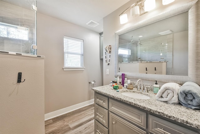 bathroom featuring hardwood / wood-style floors, vanity, and walk in shower