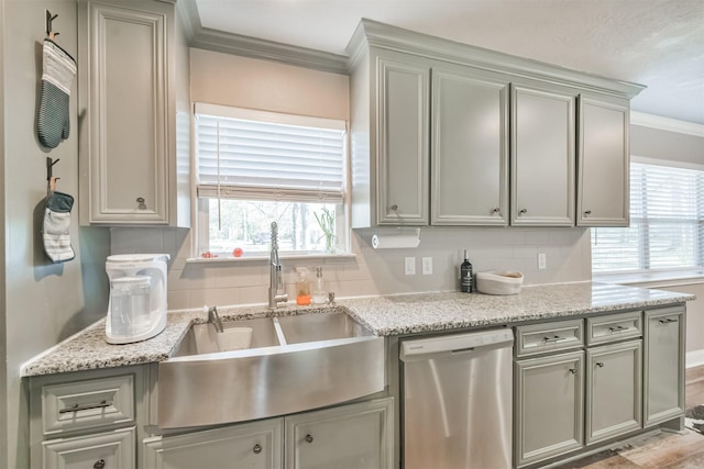 kitchen featuring dishwasher, sink, tasteful backsplash, light stone counters, and crown molding