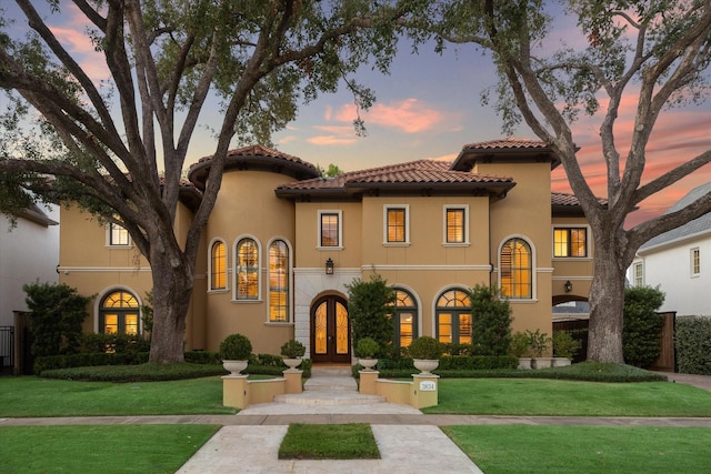 mediterranean / spanish-style house with french doors and a yard