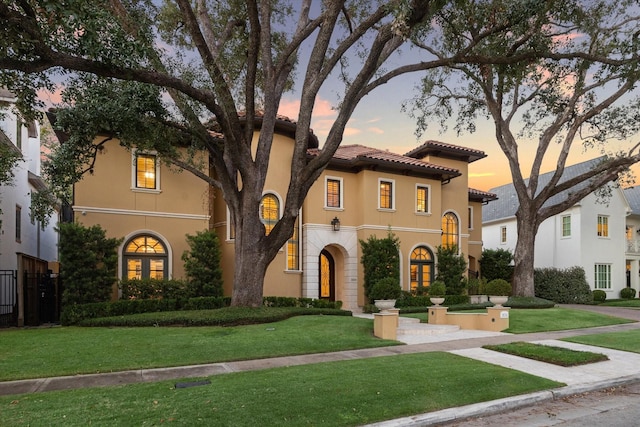 mediterranean / spanish house featuring a lawn