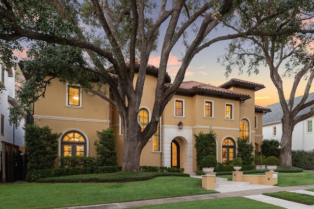 mediterranean / spanish home with a yard