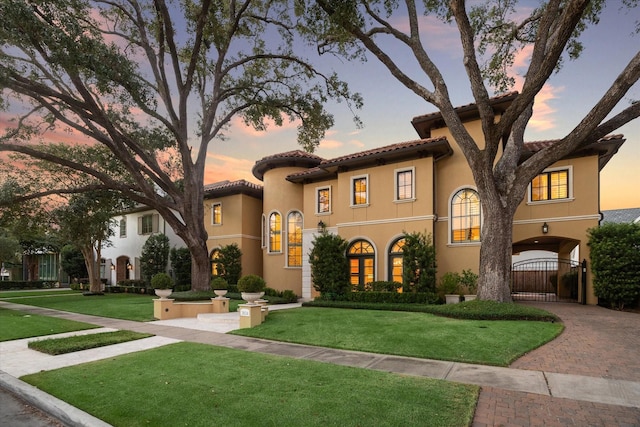 mediterranean / spanish home featuring a lawn