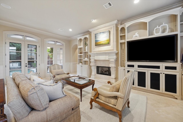 living room featuring french doors, a high end fireplace, and ornamental molding