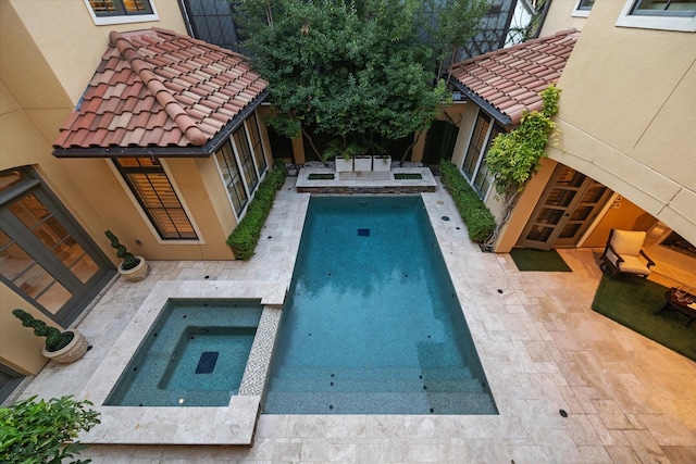 view of swimming pool with an in ground hot tub and a patio