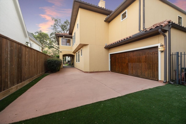 property exterior at dusk featuring a garage