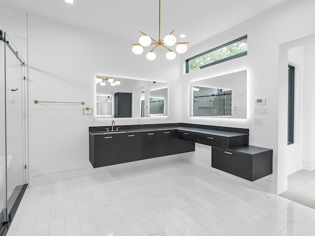 bathroom featuring a chandelier, vanity, and an enclosed shower