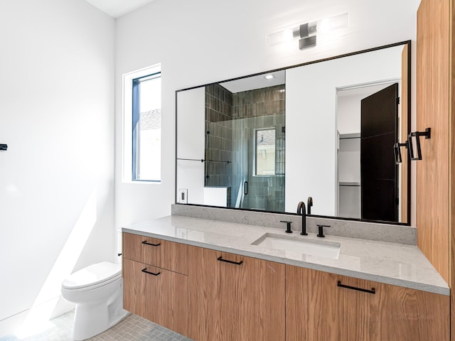 bathroom featuring tile patterned flooring, vanity, toilet, and a shower with shower door