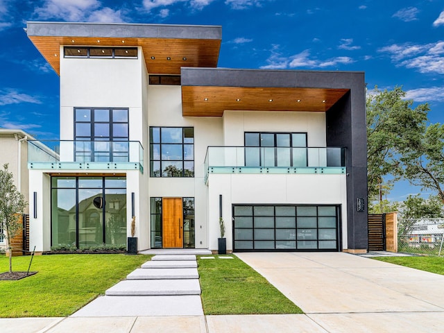 modern home with a balcony, a front lawn, and a garage