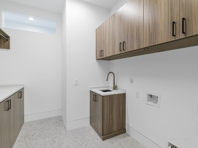 clothes washing area featuring cabinets, light tile patterned floors, hookup for a washing machine, and sink