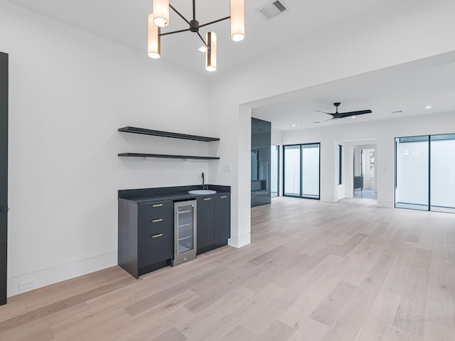 kitchen featuring ceiling fan with notable chandelier, light wood-type flooring, sink, and wine cooler