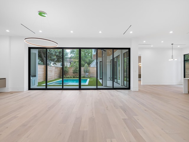 unfurnished living room with light wood-type flooring and expansive windows