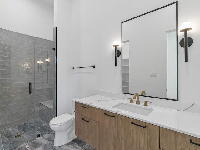 bathroom with vanity, toilet, and a shower with door