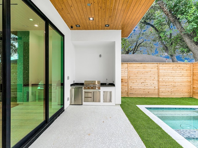 view of patio / terrace with a grill, sink, and exterior kitchen