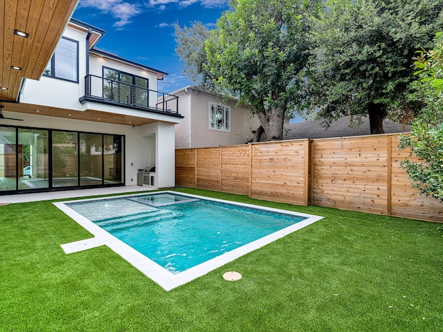 view of swimming pool with an in ground hot tub and a lawn