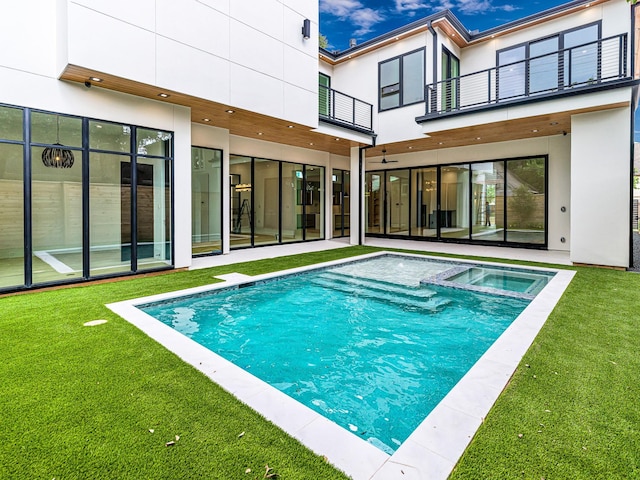 view of pool featuring an in ground hot tub and a yard