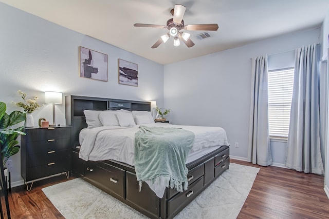 bedroom with multiple windows, dark hardwood / wood-style flooring, and ceiling fan