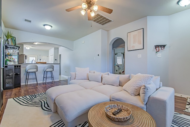 living room with dark hardwood / wood-style flooring, ceiling fan, and sink