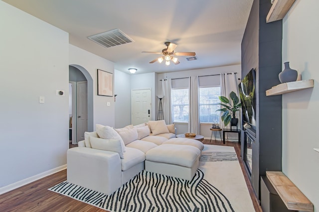 living room featuring ceiling fan and dark hardwood / wood-style floors