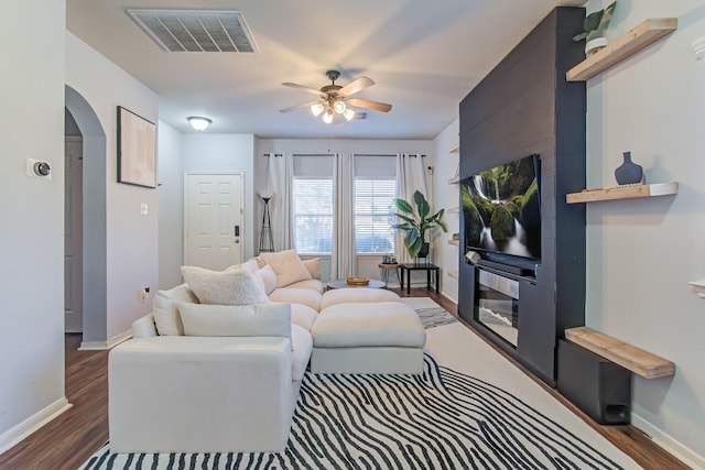 living room featuring ceiling fan and dark hardwood / wood-style floors