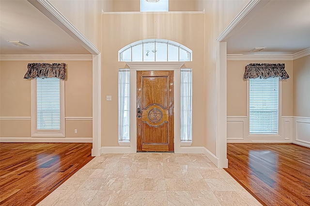 foyer featuring ornamental molding and light hardwood / wood-style flooring