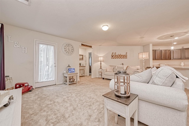 living room with a textured ceiling and light carpet