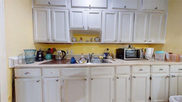 kitchen featuring white cabinetry and sink