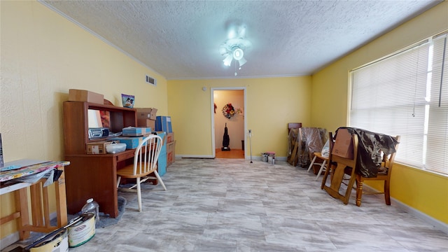 home office featuring ceiling fan and a textured ceiling