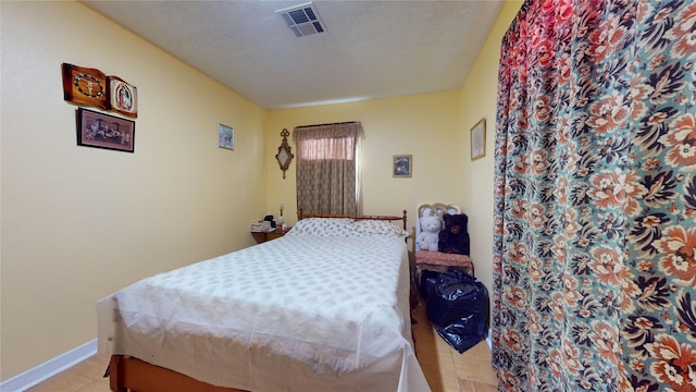 bedroom with light tile patterned floors and a textured ceiling