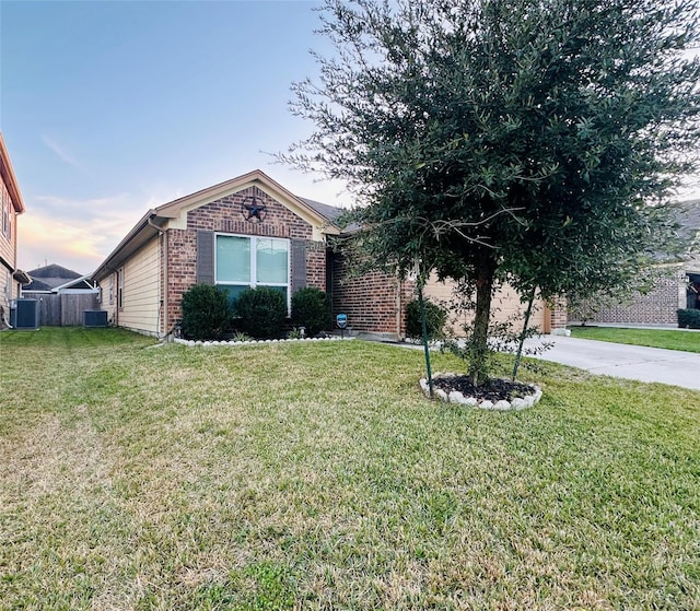 view of front of property featuring a front yard and central AC