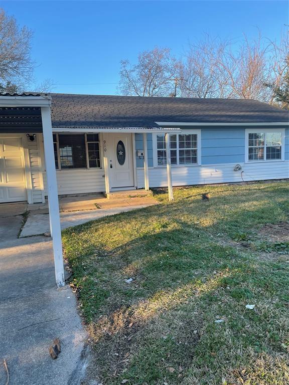 ranch-style home featuring a front yard, a carport, and covered porch