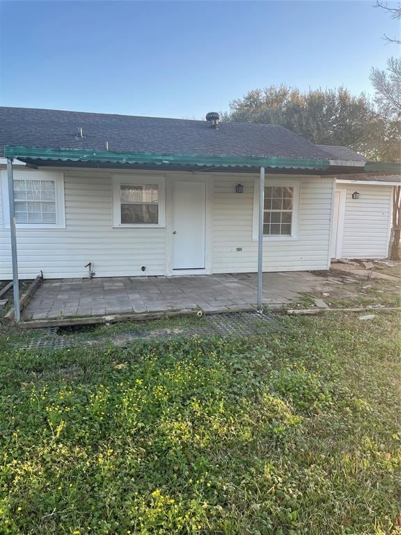 back of house with a lawn and a patio area