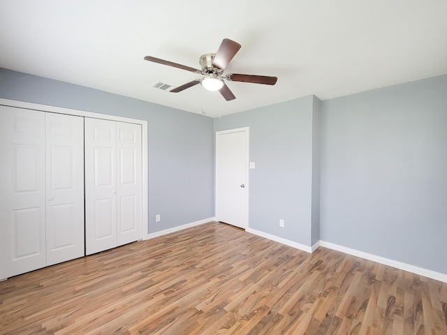 unfurnished bedroom with light hardwood / wood-style flooring, a closet, and ceiling fan