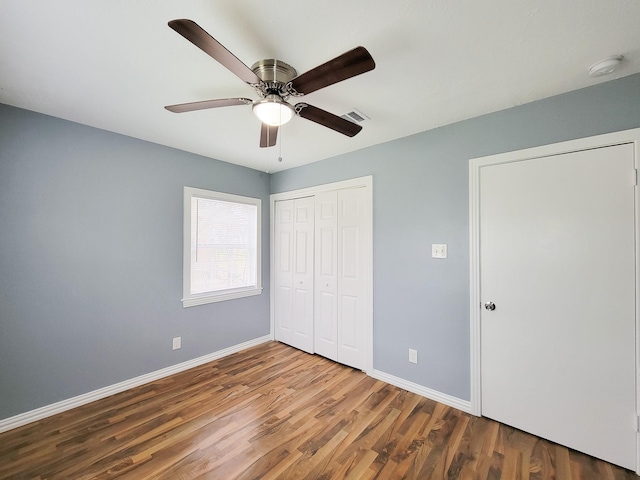 unfurnished bedroom featuring ceiling fan, hardwood / wood-style floors, and a closet