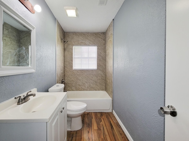 full bathroom with hardwood / wood-style flooring, vanity, toilet, and tiled shower / bath combo