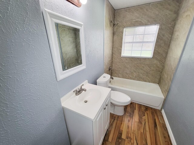 full bathroom with vanity, hardwood / wood-style flooring, toilet, and tiled shower / bath combo