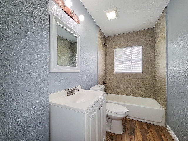 full bathroom featuring toilet, tiled shower / bath, a textured ceiling, vanity, and hardwood / wood-style flooring