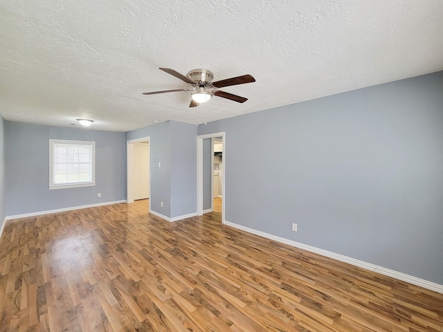 empty room with a textured ceiling, light hardwood / wood-style floors, and ceiling fan