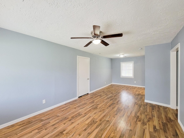 spare room featuring ceiling fan, wood-type flooring, and a textured ceiling