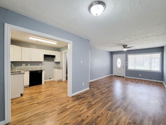 interior space with ceiling fan, sink, a textured ceiling, and light wood-type flooring