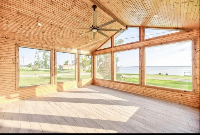 unfurnished sunroom with a water view, vaulted ceiling, a healthy amount of sunlight, and wood ceiling