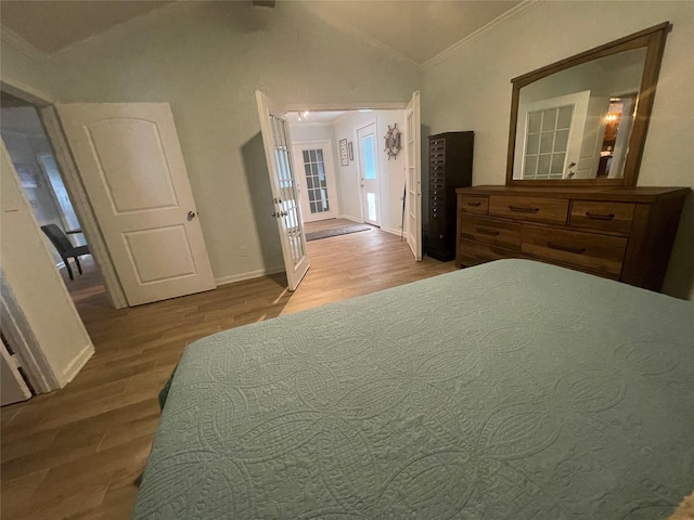 bedroom with vaulted ceiling with beams, light hardwood / wood-style flooring, and ornamental molding